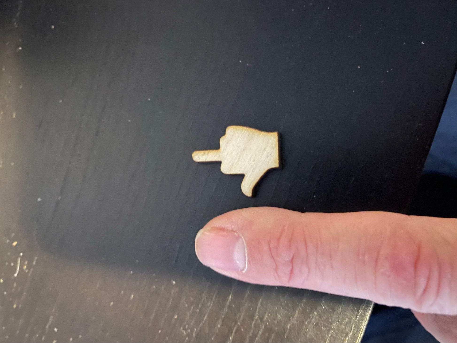 Laser Cut middle finger next to human finger